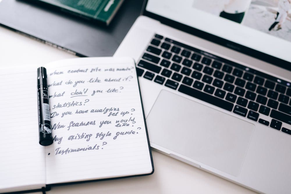 Writer editing text on laptop with style guide open