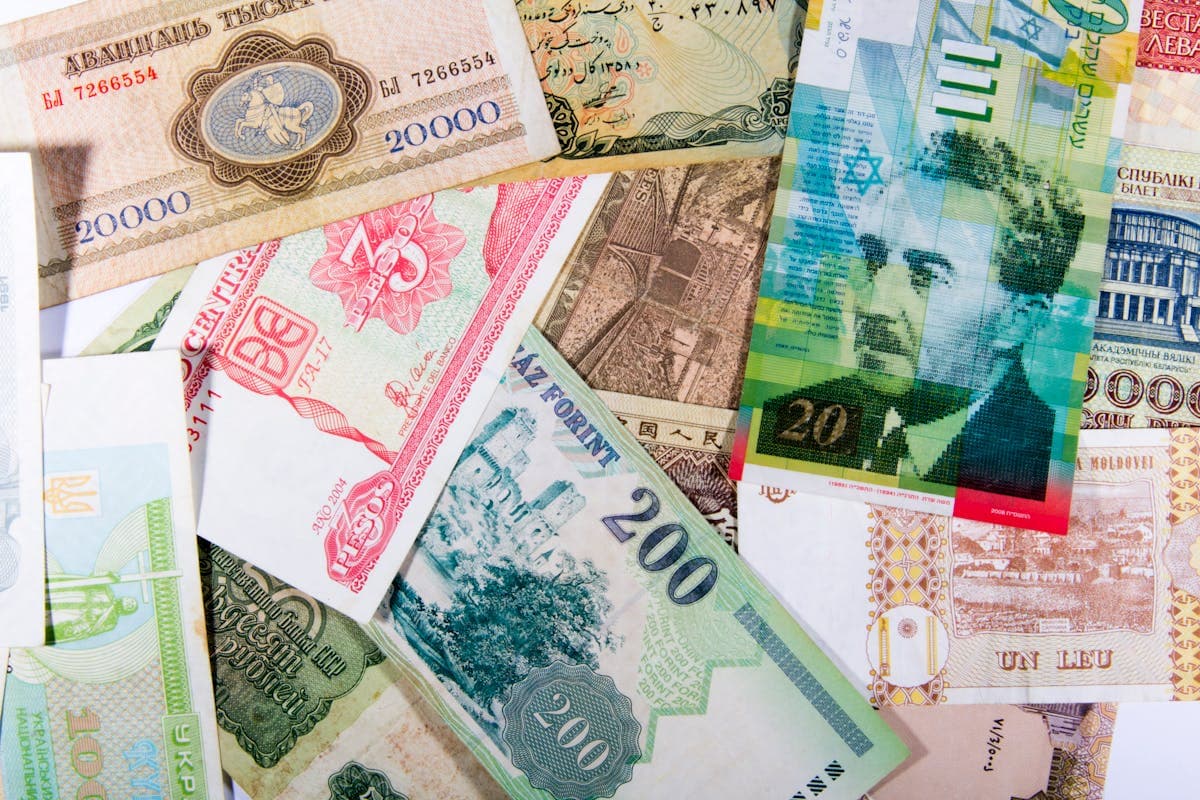 Multiple international currency bills spread on table