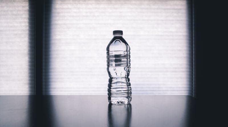Glass of water with lemon on clean desk
