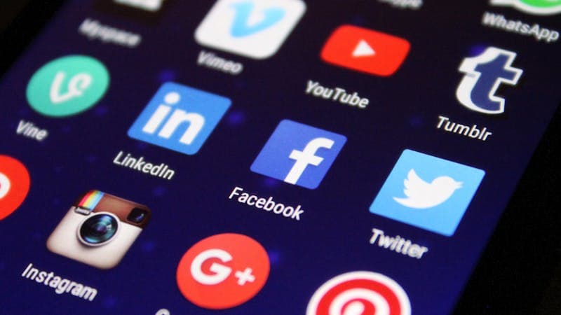 Phone showing social media feed with colorful post layouts