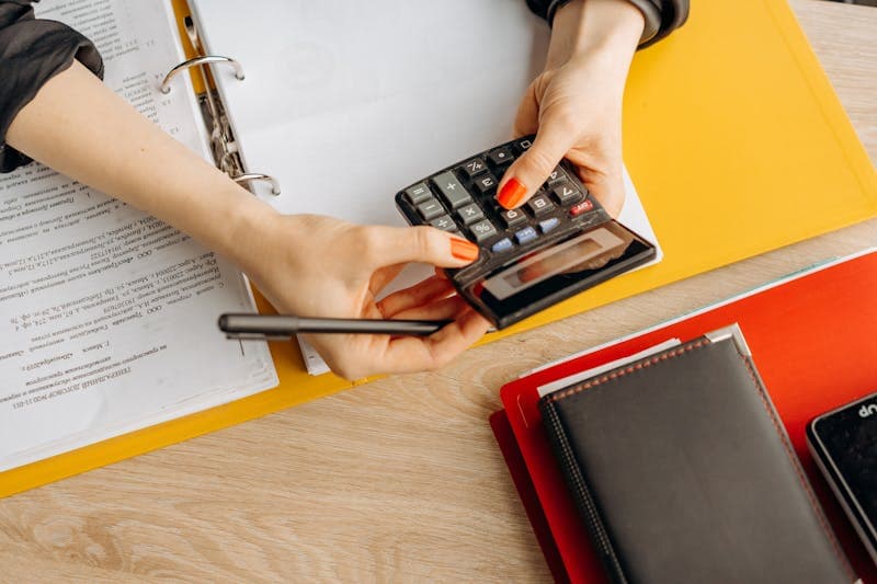 Stack of organized invoices on desk with calculator