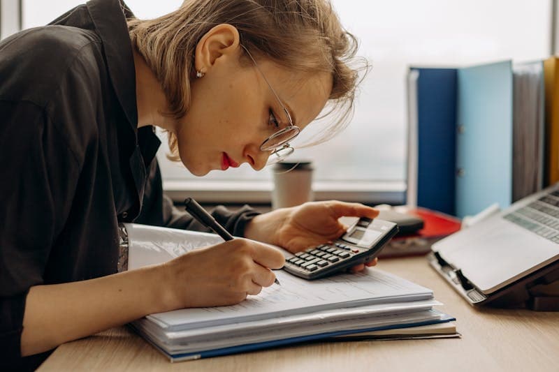 Small business owner reviewing financial documents on laptop
