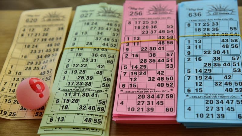 A set of colorful bingo cards and a numbered ball on a table, ready for a game night