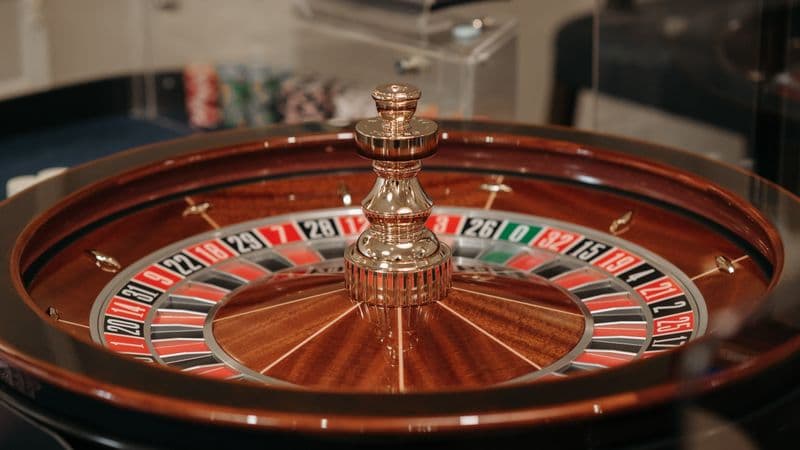 Close-up of a classic roulette wheel in a casino setting showcasing the elegant wooden design