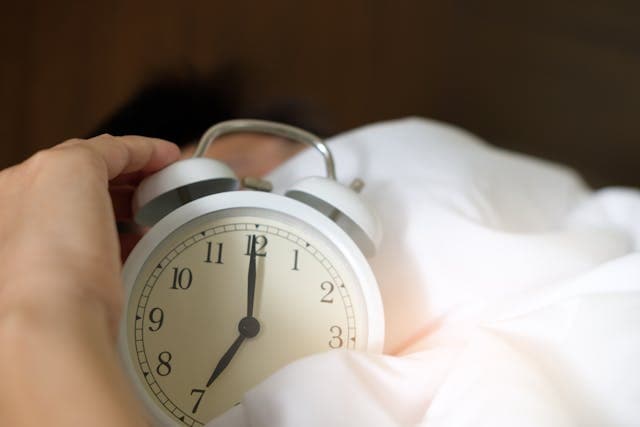 Alarm clock on a nightstand showing early morning time