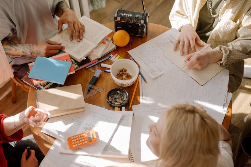 Student studying with textbooks and timer on desk