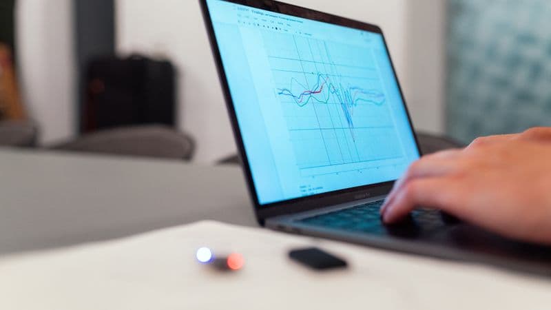 A person working on a graph analysis on a laptop for data monitoring and research
