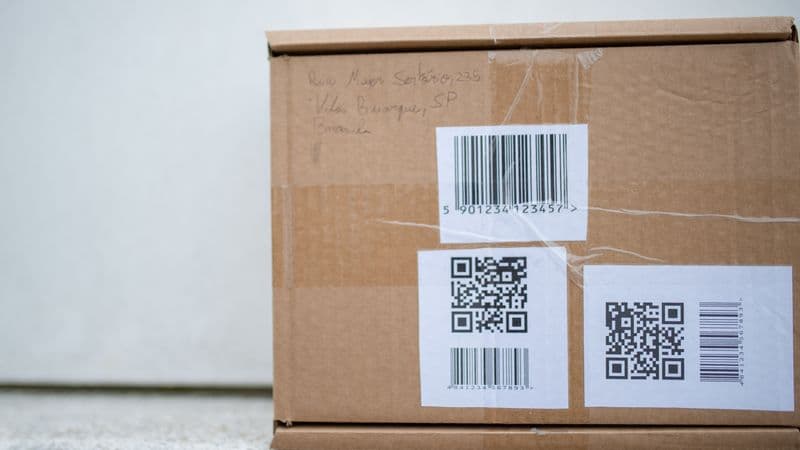Close-up of a cardboard package with QR codes and a barcode, ideal for delivery and shipping concepts